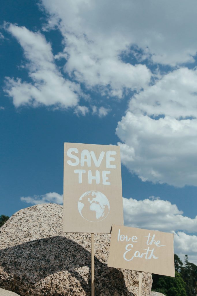 Protest signs for environmental protection against blue sky with clouds.